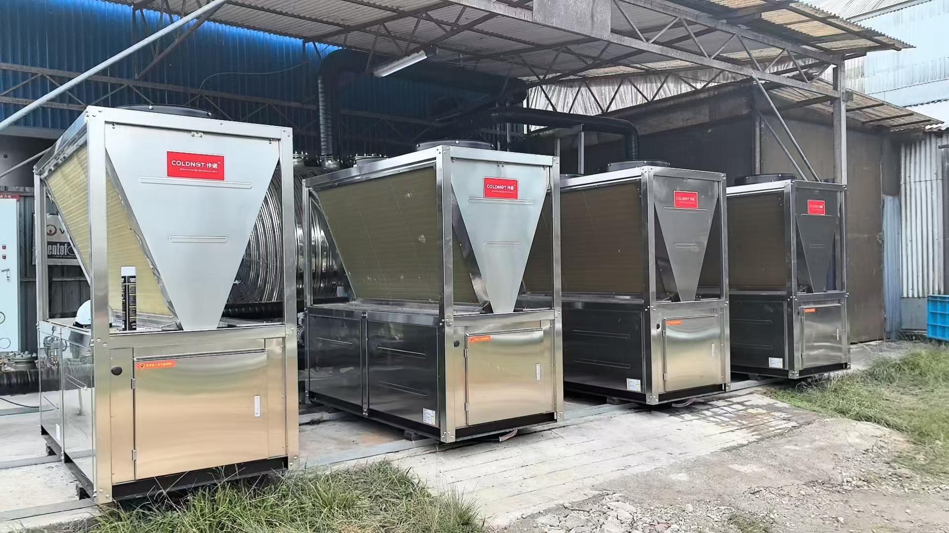 Four industrial air-source heat pump units installed outdoors
